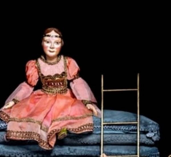 Spielfigur der Prinzessin aus einen hohen Stapel Matrazen sitzend